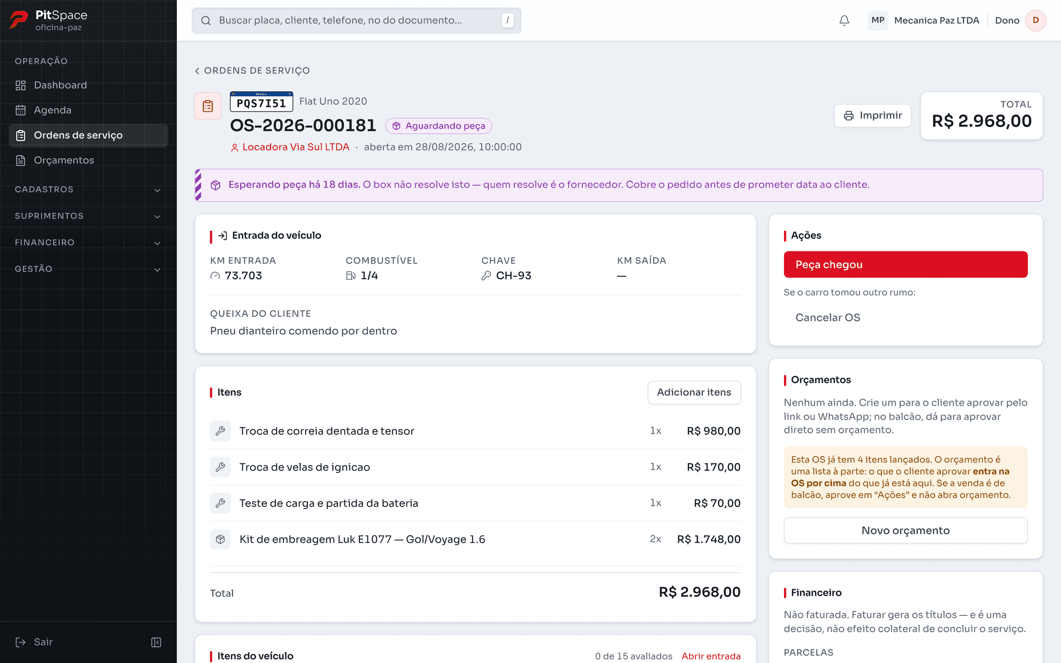 Ficha de uma ordem de serviço aguardando peça: placa, veículo, cliente e total no cabeçalho; a entrada do veículo com quilometragem, combustível e a queixa do cliente; e a lista de itens, com serviços e peças somando o total.